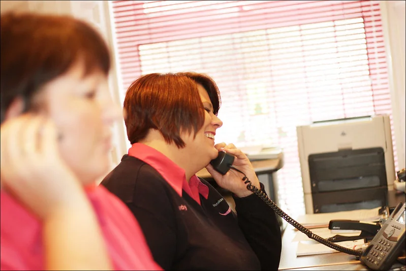 Two front desk team members at a dental practice taking patient calls